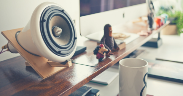 Podcast setup with light, coffee mug and other desk items.