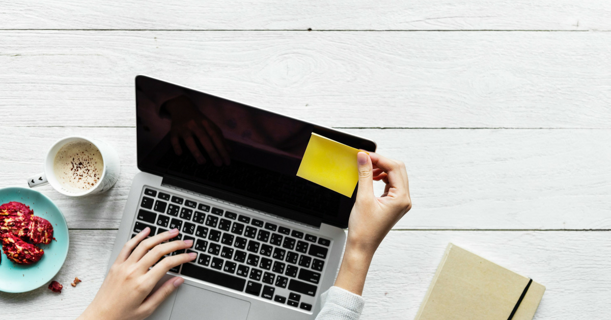 laptop on desk with sticky note.