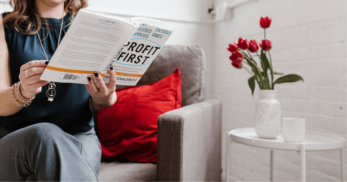 Woman sitting in chair reading a book.