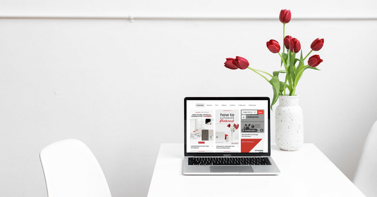 Pinterest screen on laptop beside vase of red tulips.