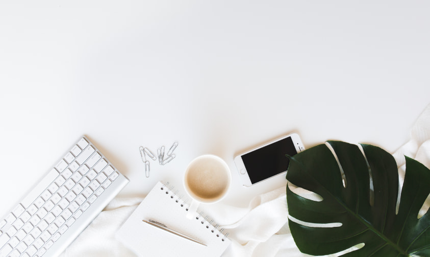 top of desk with coffee mug and smart phone.