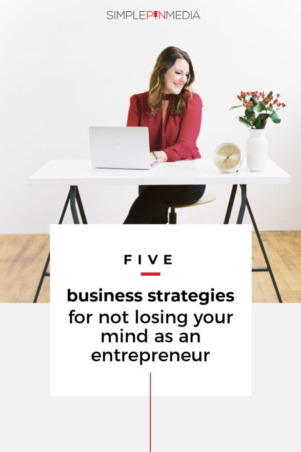 woman sitting at desk smiling typing on laptop. Text overlay "5 business strategies for not losing your mind as an entrepreneur".