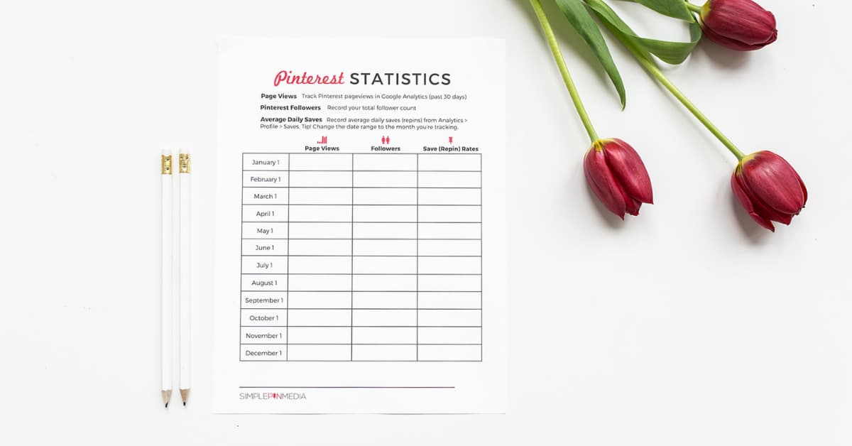 Pinterest statistics worksheet on desktop with pencils and red flowers.