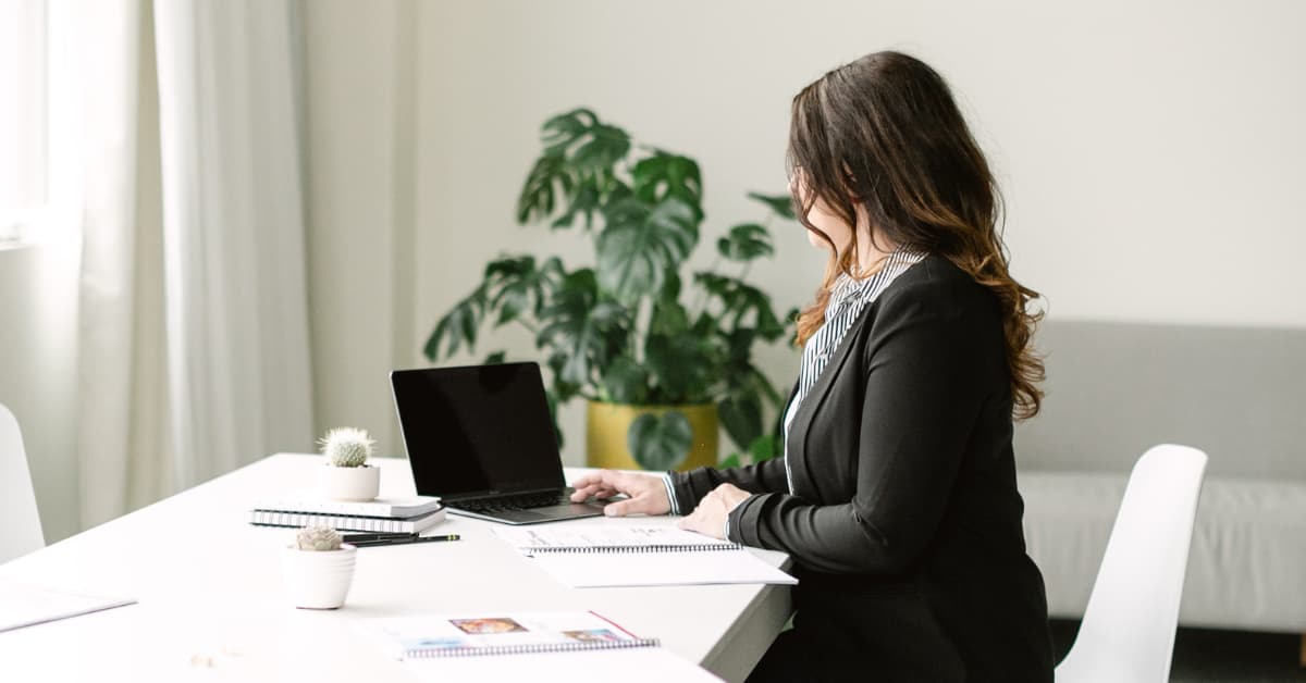 woman sitting at office desk working on computer.