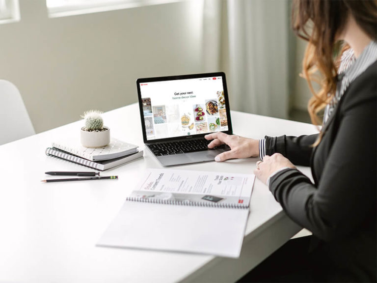 A woman sitting at a table using a laptop.