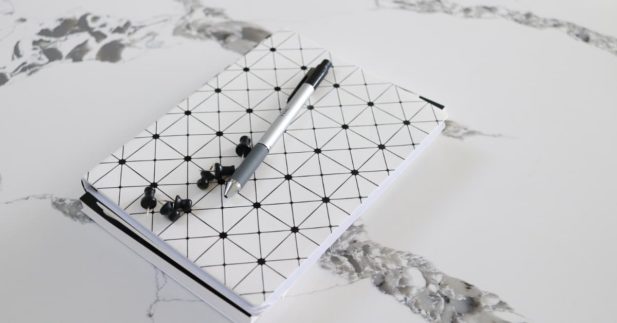 white and black polka dot journal with pen.