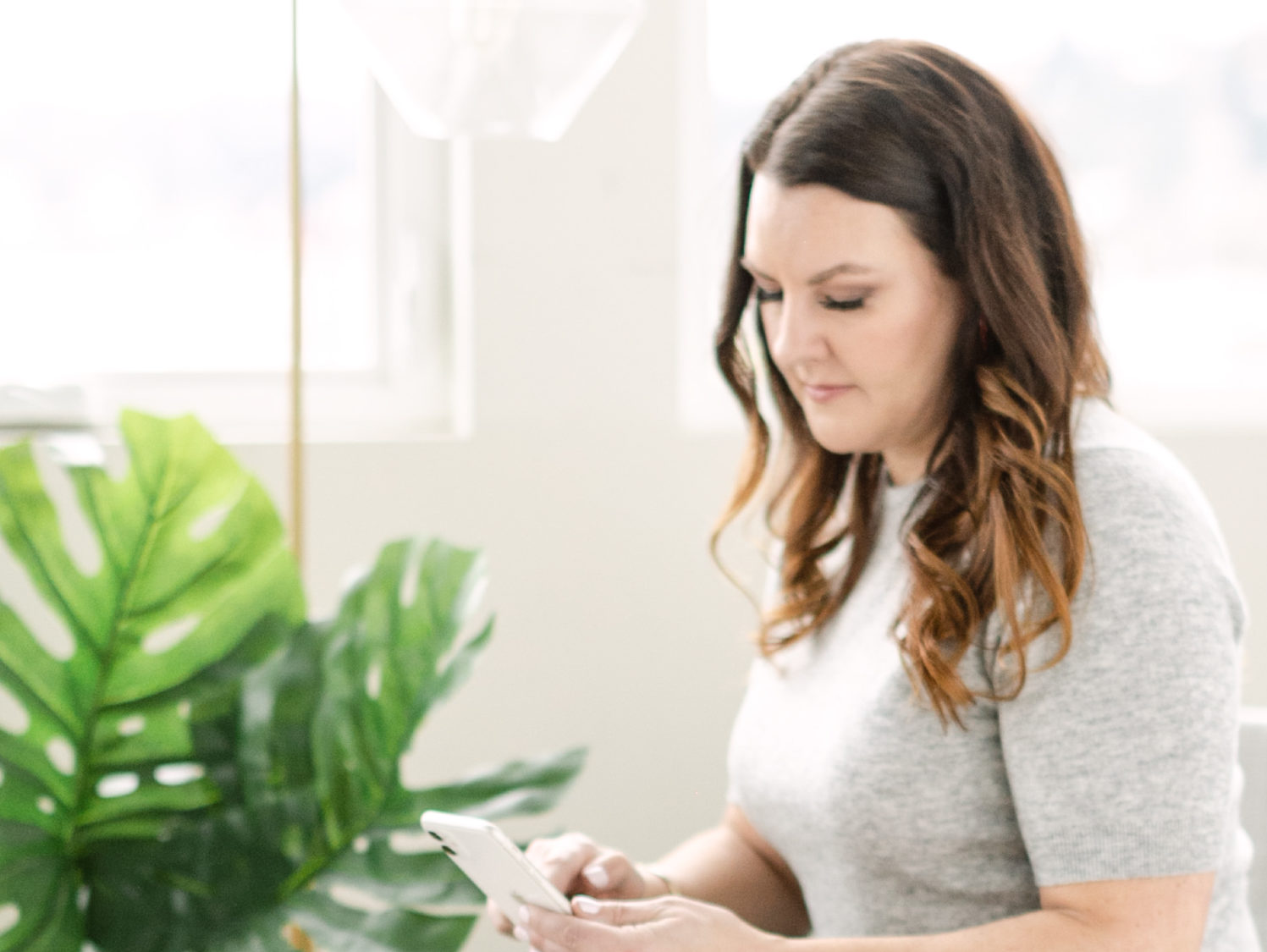 woman looking down at phone in hand.