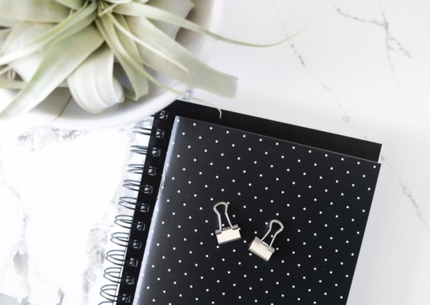 black polka dot journal with binder clips on top.