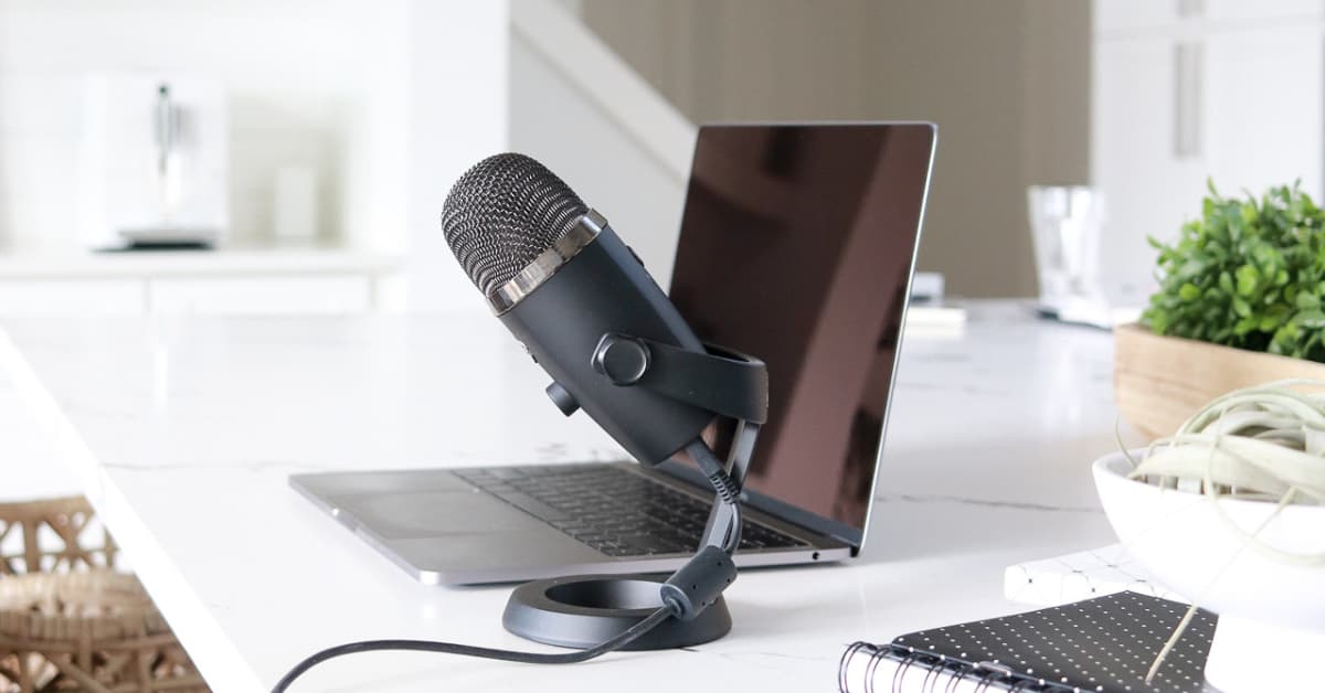 laptop on desk next to microphone.