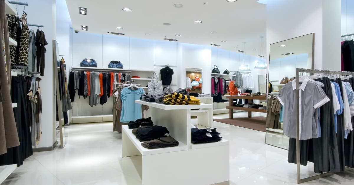 inside of retail store with clothes folded and on hangers.