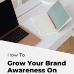 laptop on desk with text "how to grow your brand awareness on pinterest".