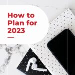 stack of journals with airpods with text "how to plan for 2023".