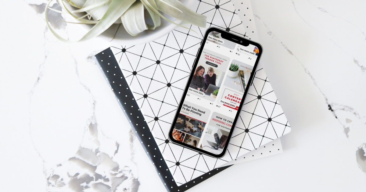 iPhone laying on top of notebook. Pinterest feed on the screen.