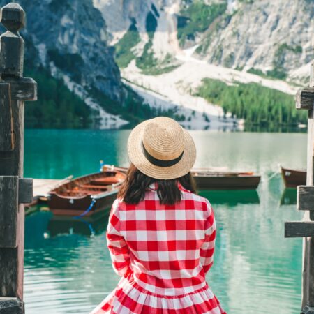 Women in red dress sitting on dock.