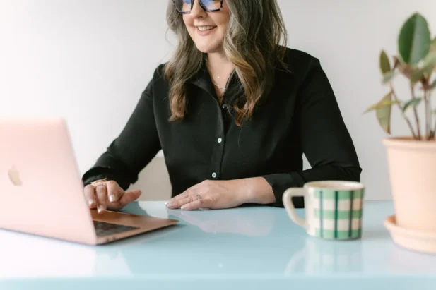 Kate, of Simple Pin Media, sitting at desk smiling.