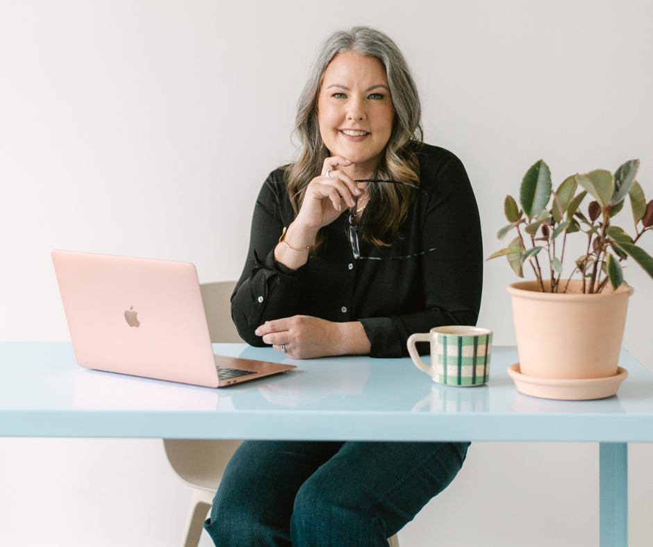 Image shows woman sitting at a desk.