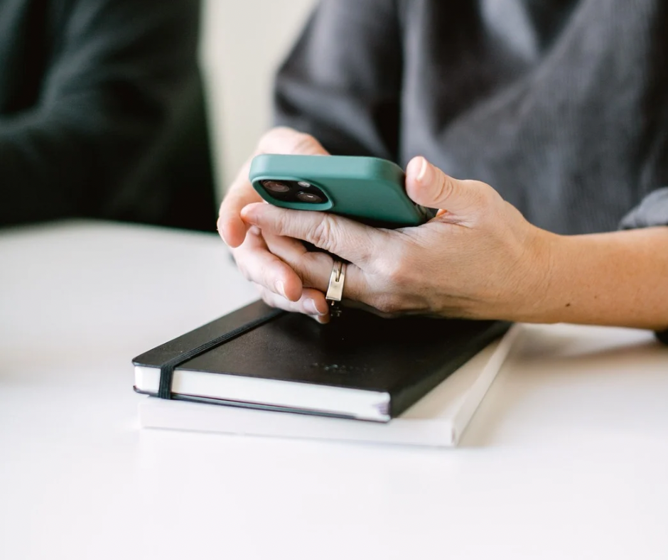 Image shows hands holding a phone.